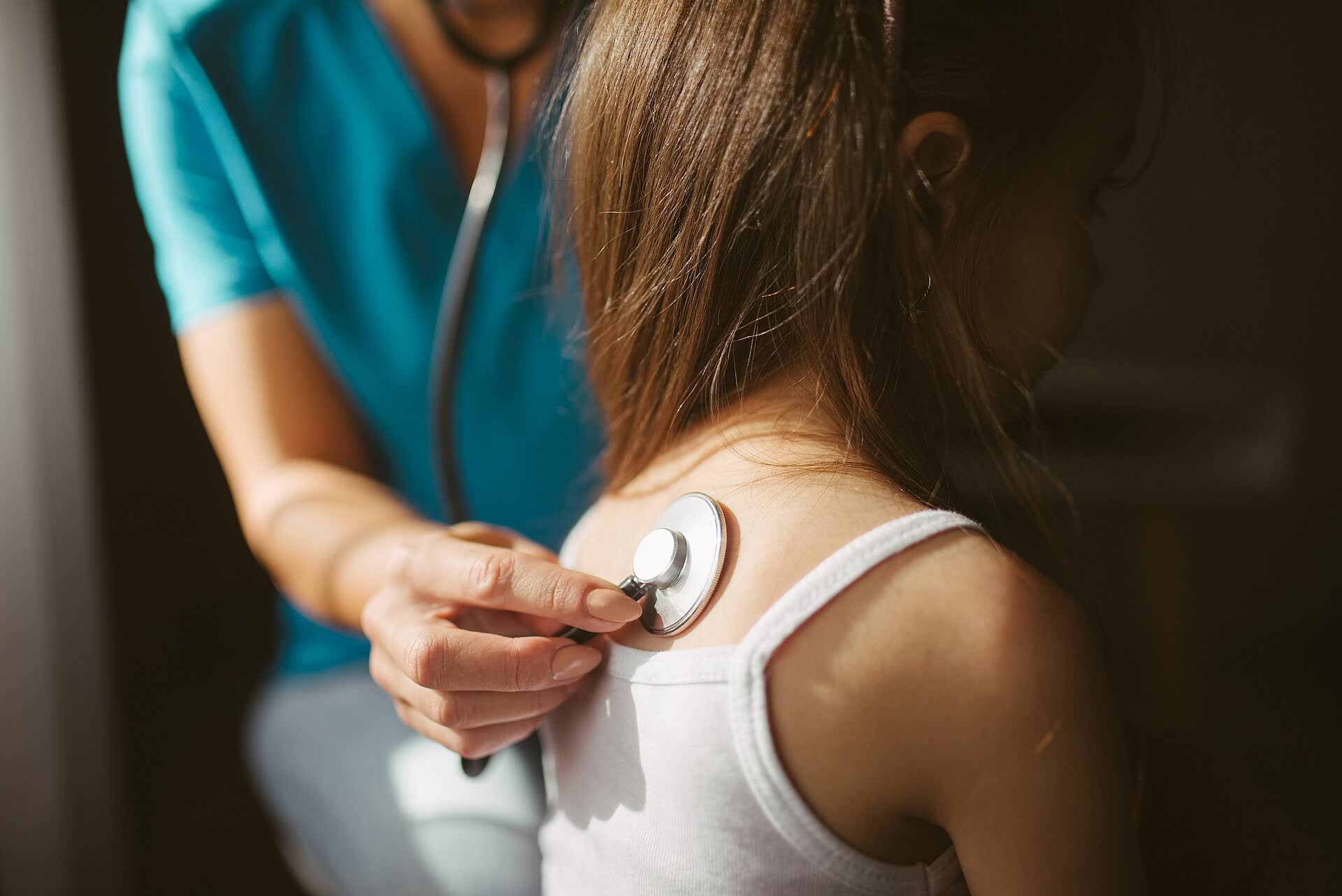 Doctor listening to a patient's back with a stethoscope
